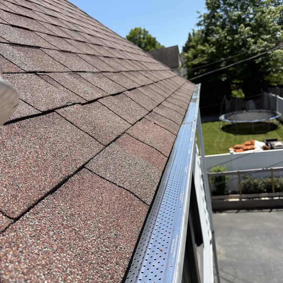 Gutter guard mesh installed along a fascia with backyard view